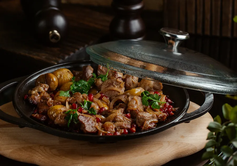 Lamb curry served in a dark pot with a lid