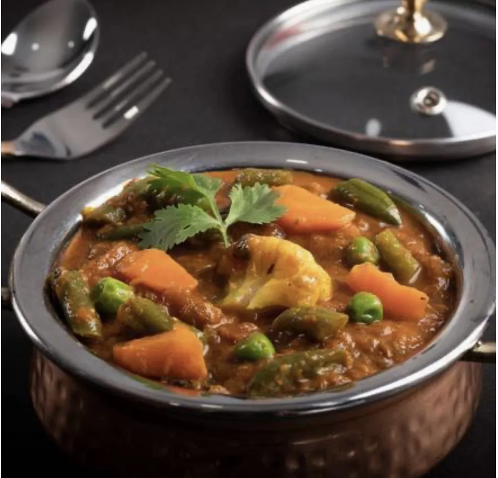 Mixed vegetable curry in a copper handi